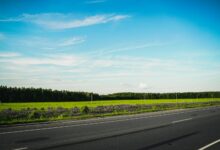 Empty rural road stretching through a sparsely populated landscape, representing distance from healthcare facilities