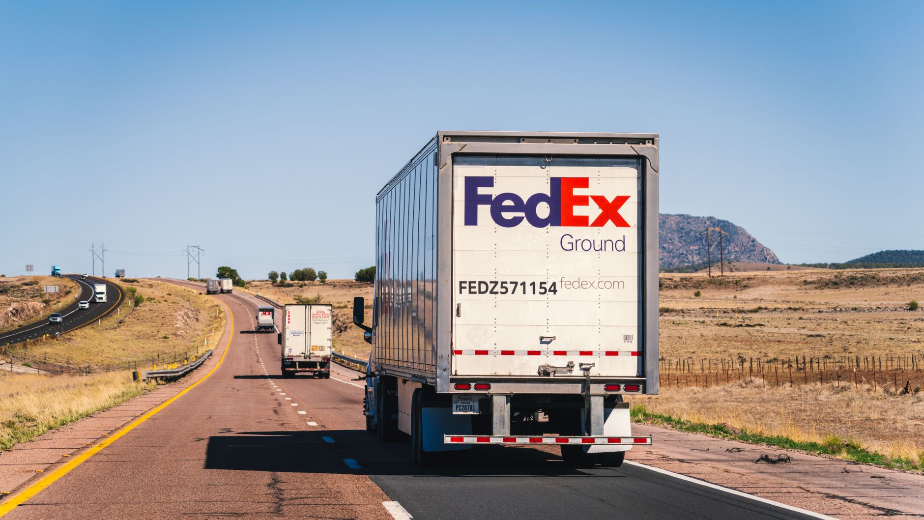 Multiple semi-trucks driving on a highway representing the freight transportation industry