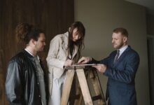 Two professionals reviewing documents at a real estate closing table