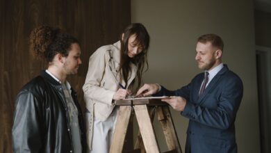 Two professionals reviewing documents at a real estate closing table