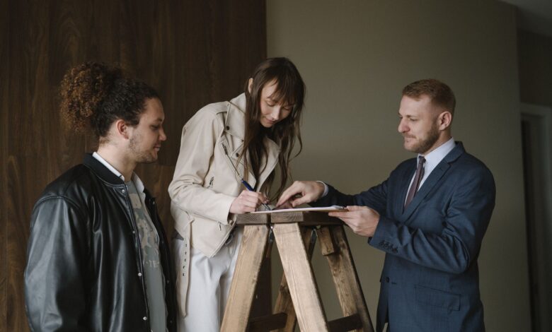 Two professionals reviewing documents at a real estate closing table