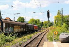 A long freight train carrying intermodal containers across open countryside