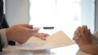Insurance broker sitting at office desk reviewing policy documents with a client