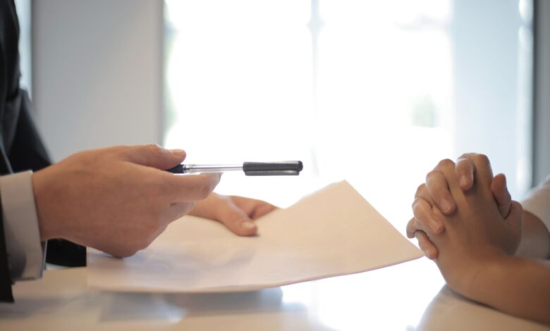 Insurance broker sitting at office desk reviewing policy documents with a client