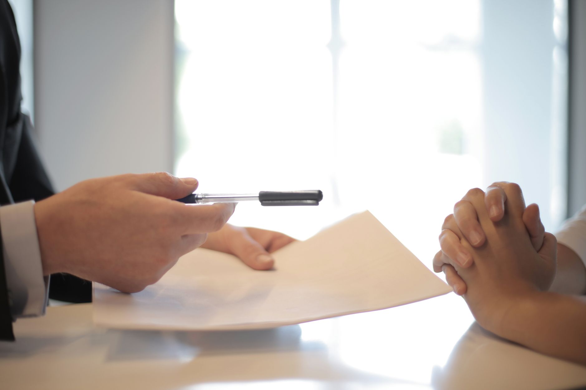 Insurance broker sitting at office desk reviewing policy documents with a client