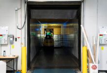 Workers moving packages inside a large regional logistics warehouse
