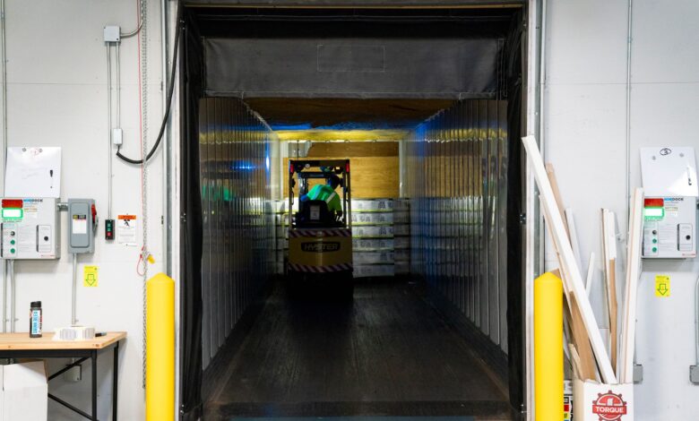 Workers moving packages inside a large regional logistics warehouse