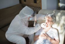 A home health nurse reviewing paperwork with an elderly patient in a residential setting