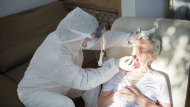 A home health nurse reviewing paperwork with an elderly patient in a residential setting
