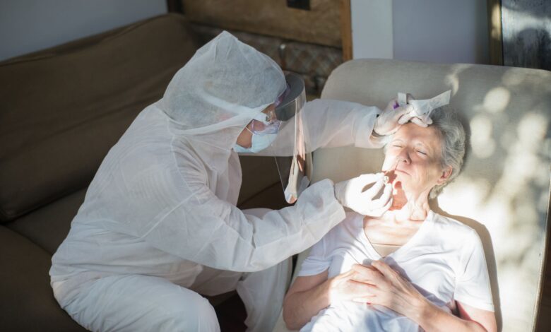 A home health nurse reviewing paperwork with an elderly patient in a residential setting