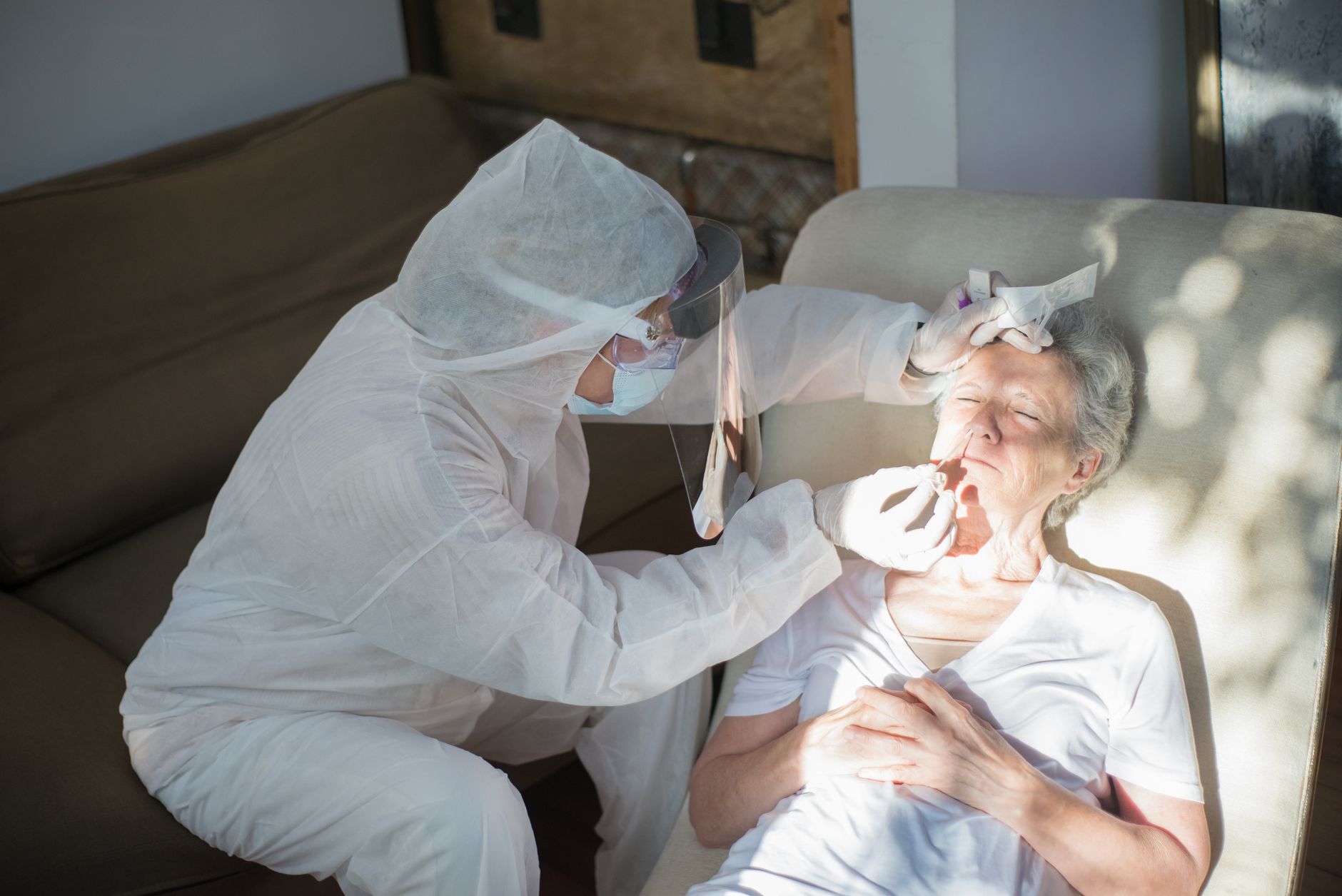 A home health nurse reviewing paperwork with an elderly patient in a residential setting
