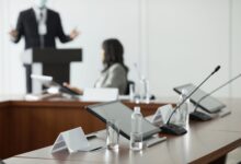 Empty corporate boardroom with long conference table and office chairs