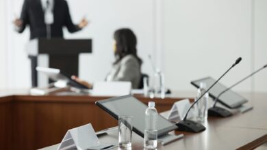 Empty corporate boardroom with long conference table and office chairs