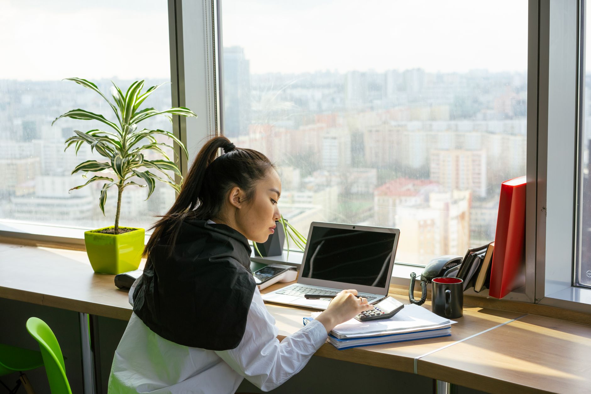 Professional working at a financial office desk reviewing investment data