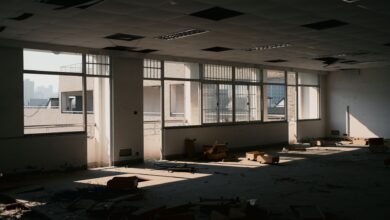 Empty floors inside a vacant commercial office tower with dark windows and unused workstations