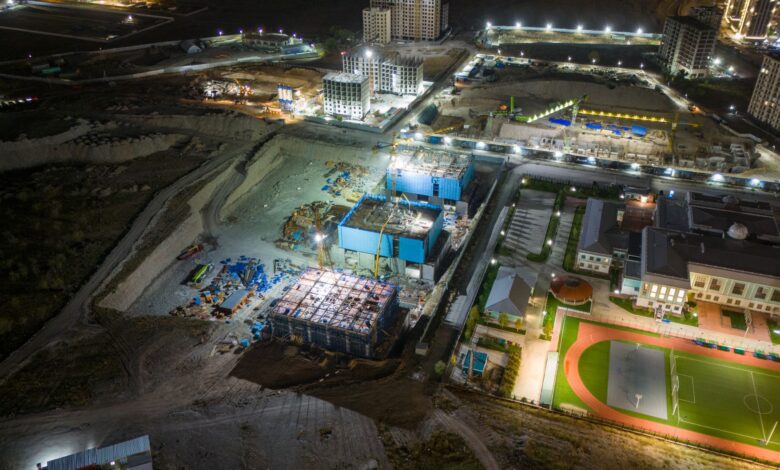 Aerial view of a commercial construction site with cranes and building frames