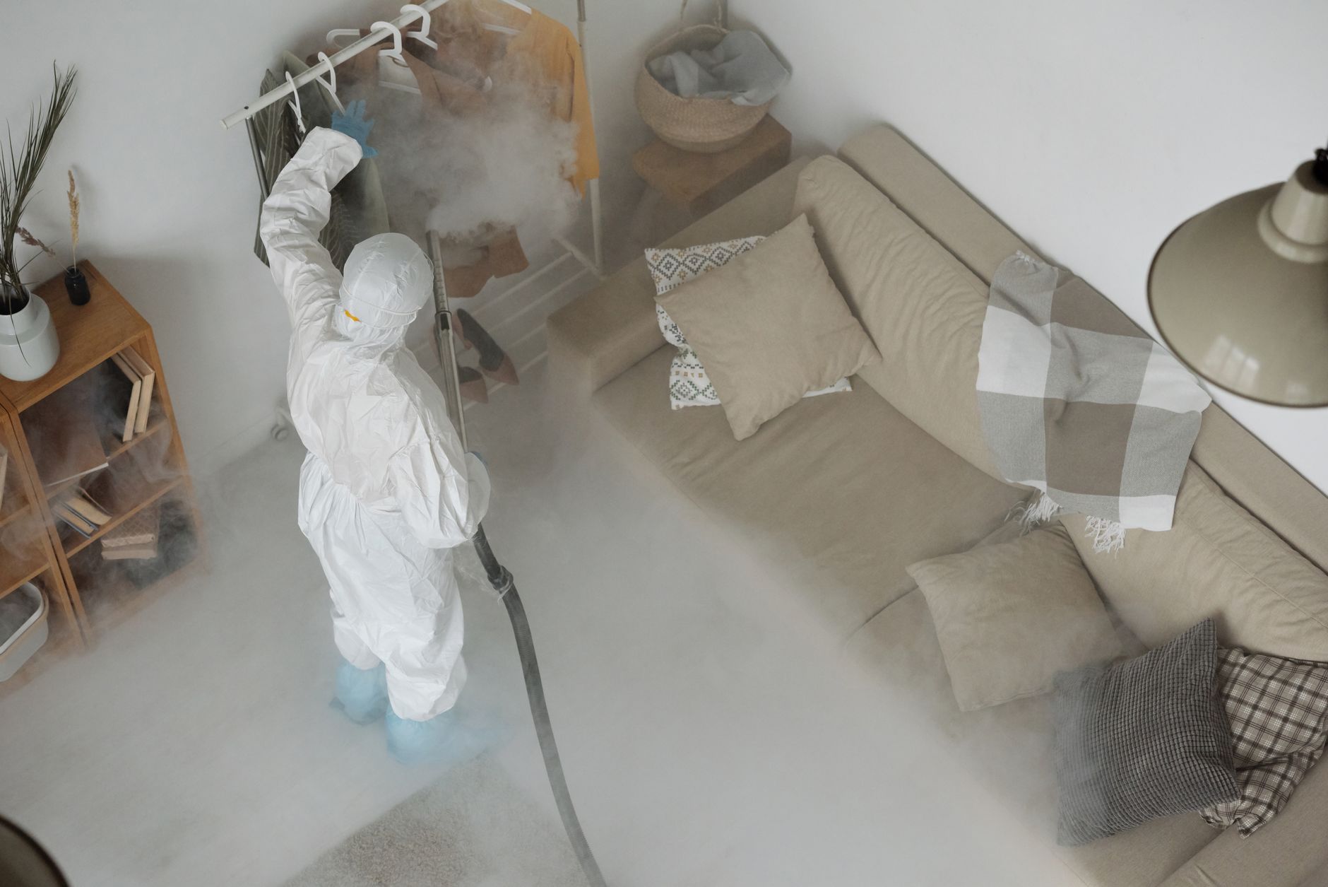 A pest control technician in uniform inspecting a residential property