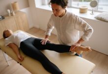 A physical therapist working with a patient in a clinical rehabilitation setting