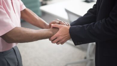 Two professionals reviewing documents at a conference table representing a business merger discussion