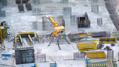 Aerial view of a large commercial construction site with cranes and framework