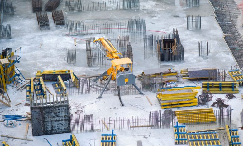 Aerial view of a large commercial construction site with cranes and framework
