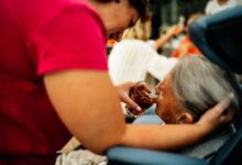 A hospice caregiver sitting with an elderly patient in a quiet home setting