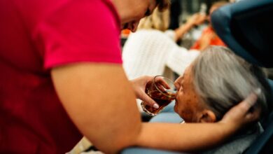A hospice caregiver sitting with an elderly patient in a quiet home setting
