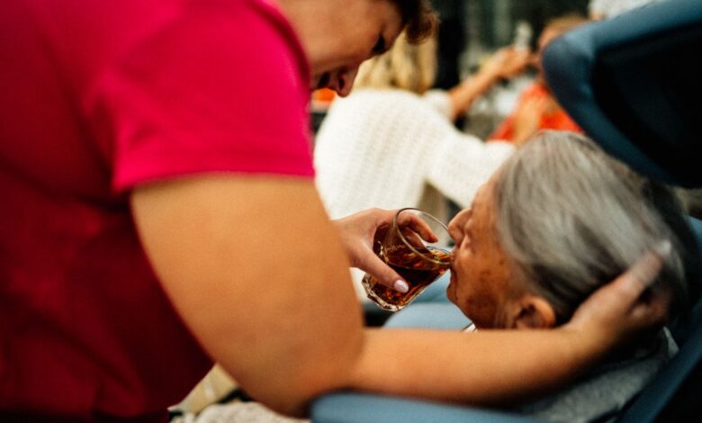 A hospice caregiver sitting with an elderly patient in a quiet home setting