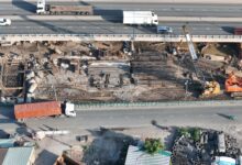 Aerial view of a large commercial construction site with cranes and building frameworks