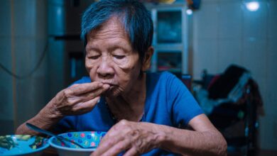 A home health aide assisting an elderly patient in a residential setting