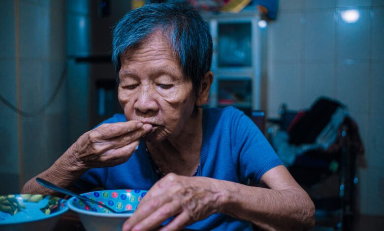 A home health aide assisting an elderly patient in a residential setting