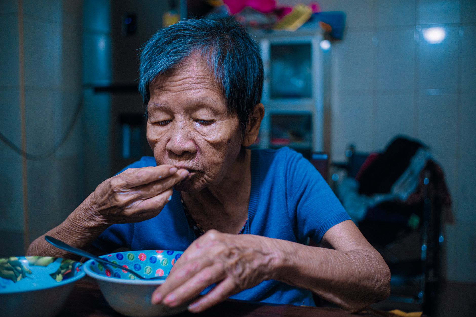 A home health aide assisting an elderly patient in a residential setting
