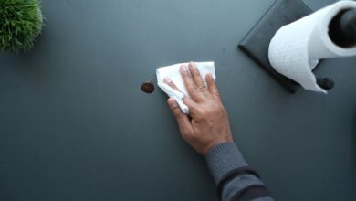 Commercial cleaner wiping down an office desk in a modern workspace