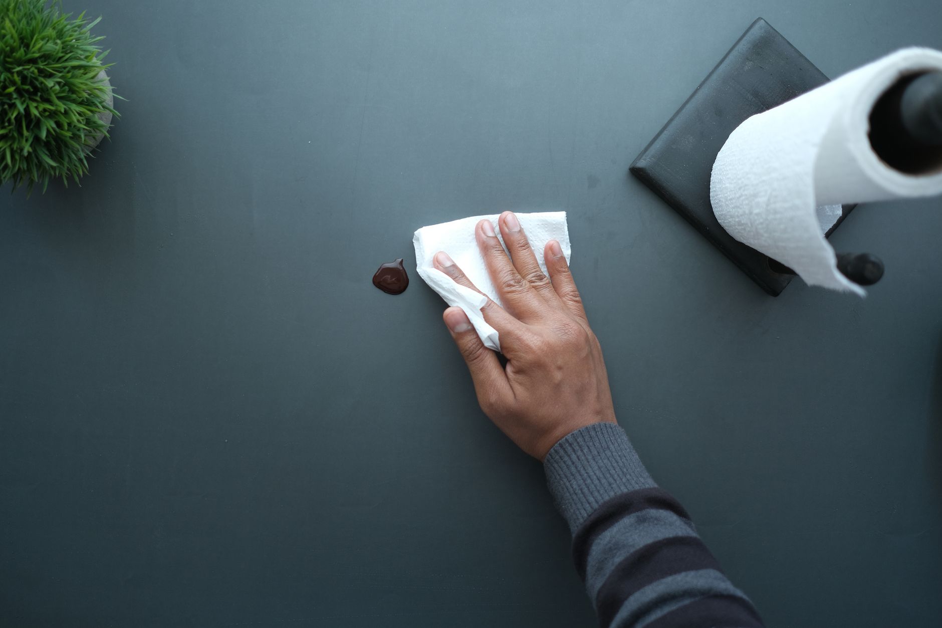 Commercial cleaner wiping down an office desk in a modern workspace