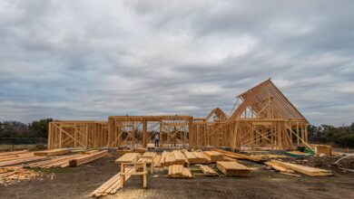Aerial view of a residential construction site with framed homes and cleared land
