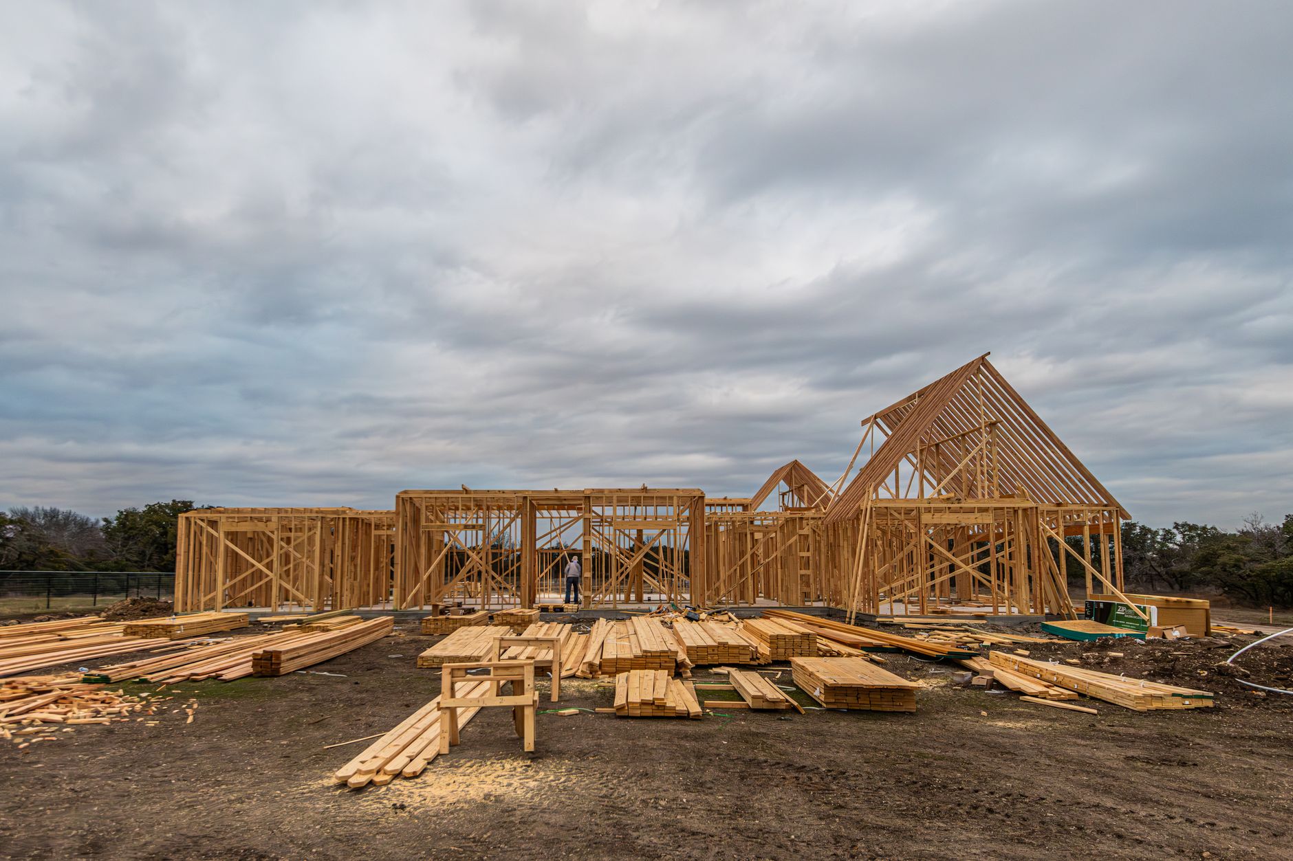 Aerial view of a residential construction site with framed homes and cleared land