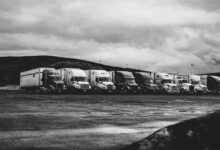 A row of commercial trucks parked in a fleet yard representing small fleet operations