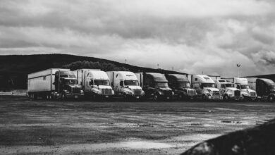 A row of commercial trucks parked in a fleet yard representing small fleet operations