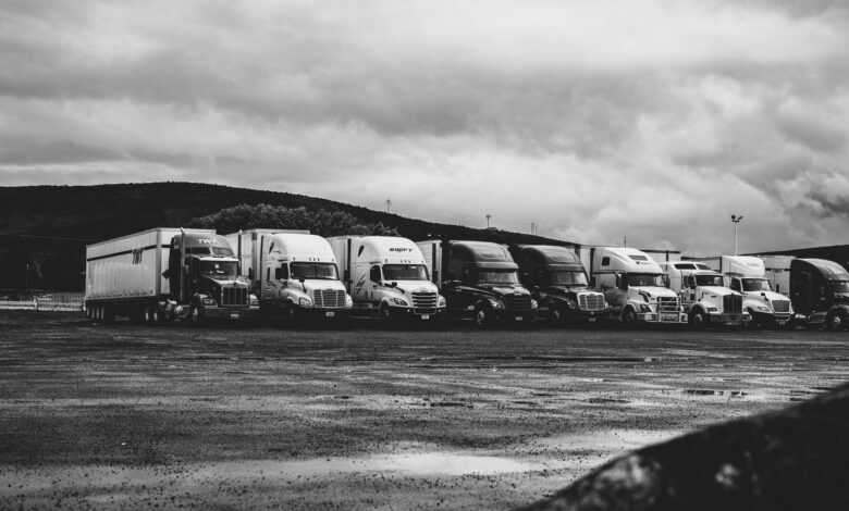 A row of commercial trucks parked in a fleet yard representing small fleet operations
