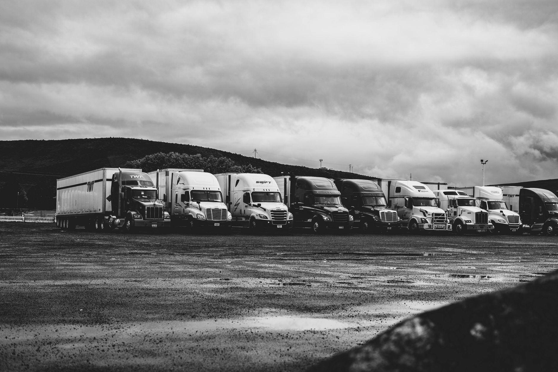 A row of commercial trucks parked in a fleet yard representing small fleet operations