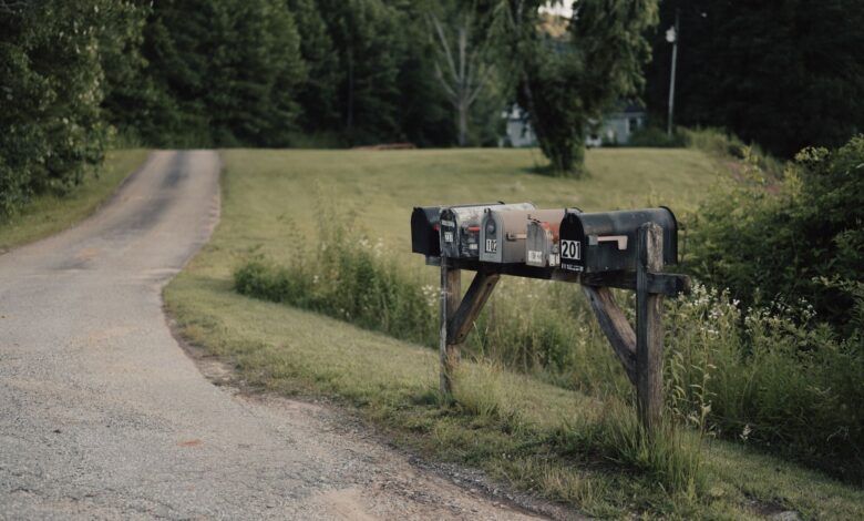 A delivery truck driving along a remote rural road surrounded by open fields