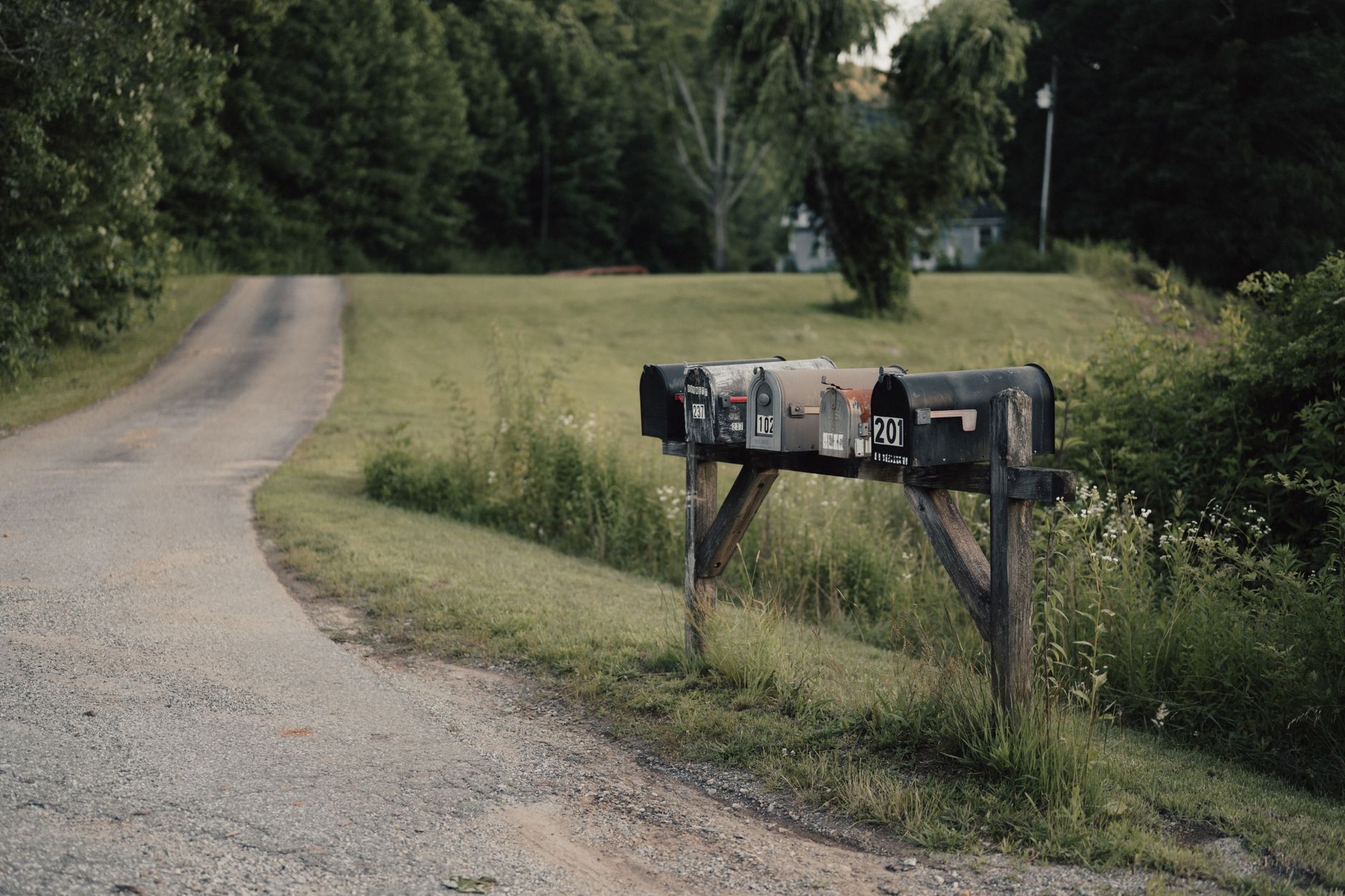 A delivery truck driving along a remote rural road surrounded by open fields