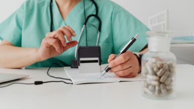 A healthcare billing professional reviewing insurance claims at a desk with multiple monitors