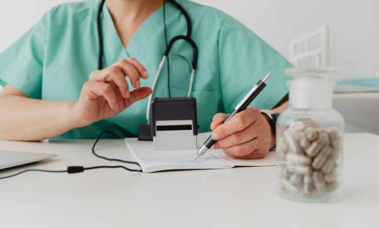 A healthcare billing professional reviewing insurance claims at a desk with multiple monitors