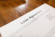 Stack of mortgage loan documents on a desk representing FHA servicing portfolios