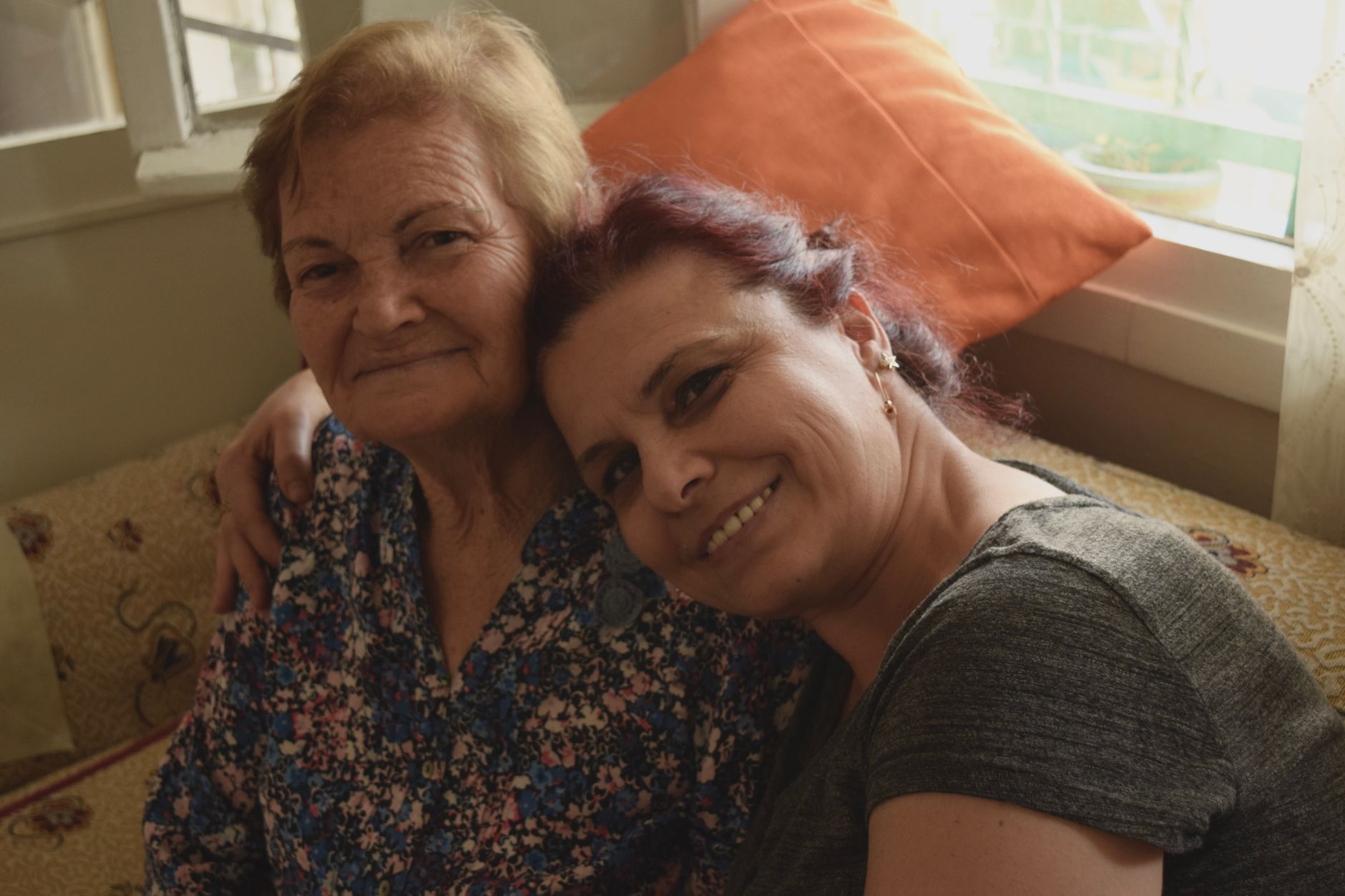A caregiver assisting an elderly patient in a home setting with medical equipment nearby