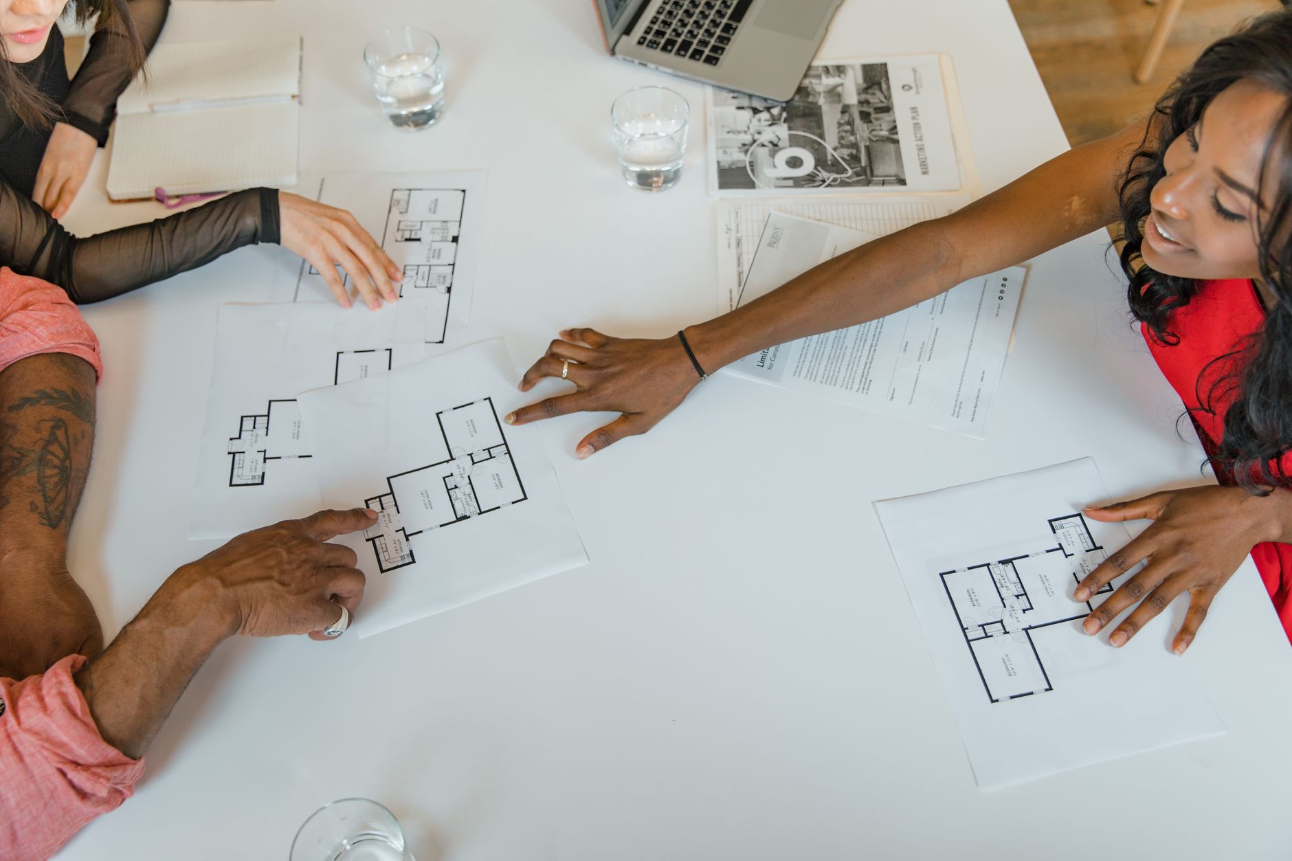 Two professionals reviewing real estate or financial documents at a conference table