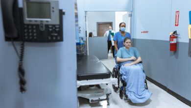 A quiet hallway inside a skilled nursing facility with medical equipment visible