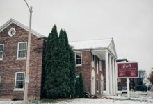 Exterior of a traditional funeral home building with stone facade and quiet entrance