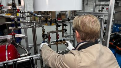 A plumber working on pipes under a sink in a residential property